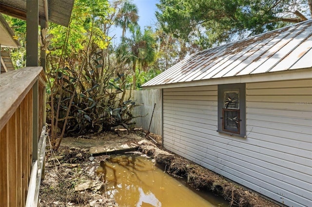 10844 W Yulee Dr, Homosassa, FL 34448 - view of side of home featuring a standing seam roof, a metal roof, and an outbuilding