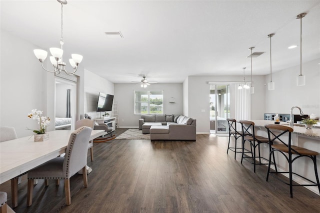 12313 Criollo Rd, Spring Hill, FL 34610 - dining area with a chandelier, dark wood-type flooring, a ceiling fan, and baseboards