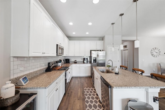 12313 Criollo Rd, Spring Hill, FL 34610 - kitchen featuring stainless steel appliances, a sink, a kitchen breakfast bar, dark wood-style flooring, and tasteful backsplash