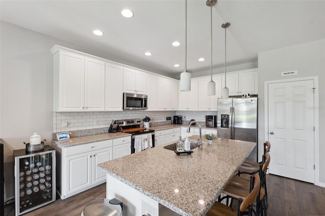 12313 Criollo Rd, Spring Hill, FL 34610 - kitchen with appliances with stainless steel finishes, a breakfast bar, dark wood-style flooring, tasteful backsplash, and recessed lighting