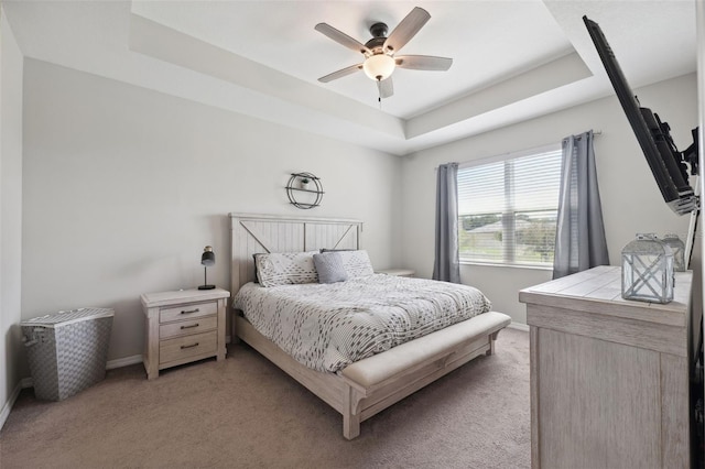 12313 Criollo Rd, Spring Hill, FL 34610 - bedroom with a tray ceiling, light carpet, baseboards, and a ceiling fan