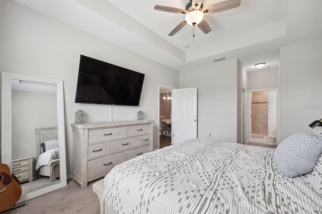 12313 Criollo Rd, Spring Hill, FL 34610 - bedroom with a raised ceiling, light carpet, ensuite bathroom, and a ceiling fan