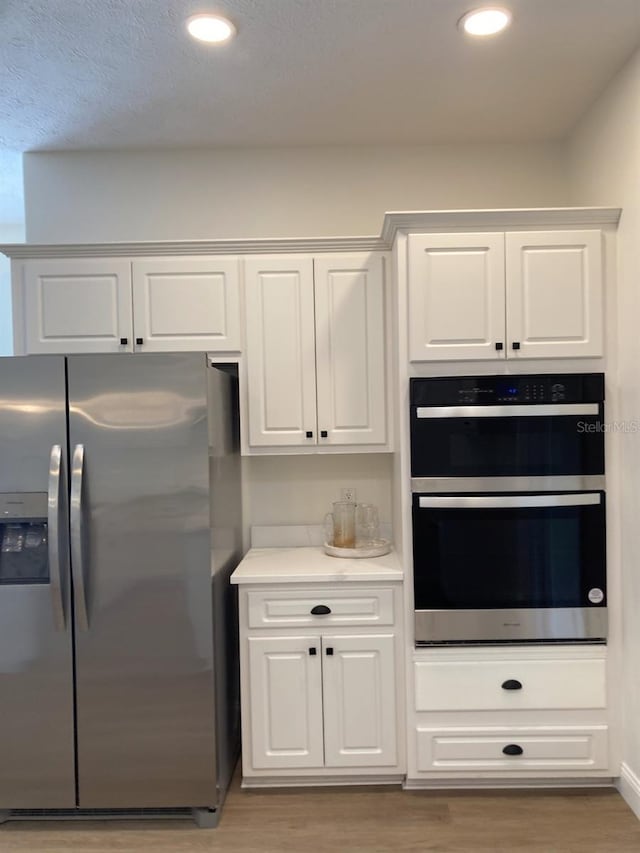 2543 E Marcia St, Inverness, FL 34453 - kitchen with stainless steel appliances, light wood-style floors, white cabinetry, light countertops, and recessed lighting