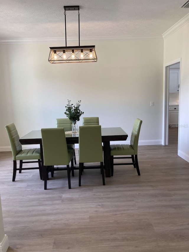 2543 E Marcia St, Inverness, FL 34453 - dining room with crown molding, baseboards, wood finished floors, and a textured ceiling