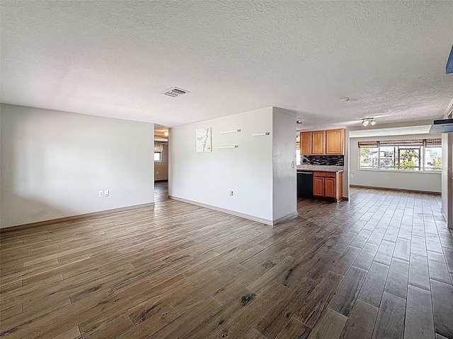 6601 Nautical Isle, Hudson, FL 34667 - unfurnished living room with dark wood-style flooring, a textured ceiling, and baseboards