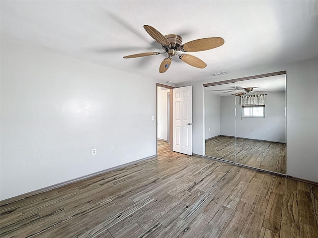 6601 Nautical Isle, Hudson, FL 34667 - unfurnished bedroom featuring wood finished floors, a closet, a ceiling fan, and baseboards