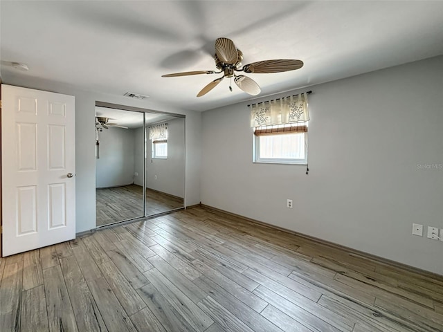 6601 Nautical Isle, Hudson, FL 34667 - unfurnished bedroom featuring multiple windows, a closet, wood finished floors, and a ceiling fan