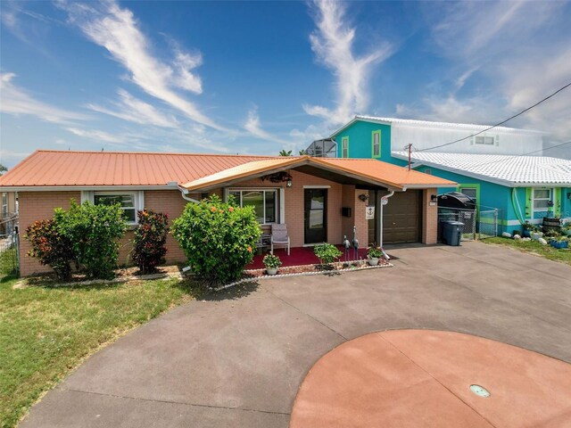 6601 Nautical Isle, Hudson, FL 34667 - single story home with driveway, an attached garage, covered porch, brick siding, and metal roof