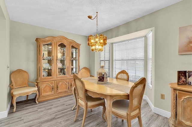 4841 Wakefield Ct Unit 4841, New Port Richey, FL 34655 - dining area featuring a chandelier, light wood-style flooring, and baseboards