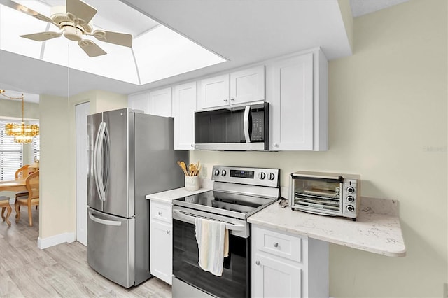 4841 Wakefield Ct Unit 4841, New Port Richey, FL 34655 - kitchen featuring stainless steel appliances, light wood-style floors, a chandelier, white cabinetry, and ceiling fan