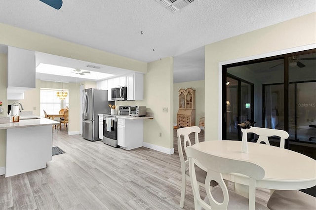 4841 Wakefield Ct Unit 4841, New Port Richey, FL 34655 - kitchen with stainless steel appliances, baseboards, a sink, light countertops, and a textured ceiling