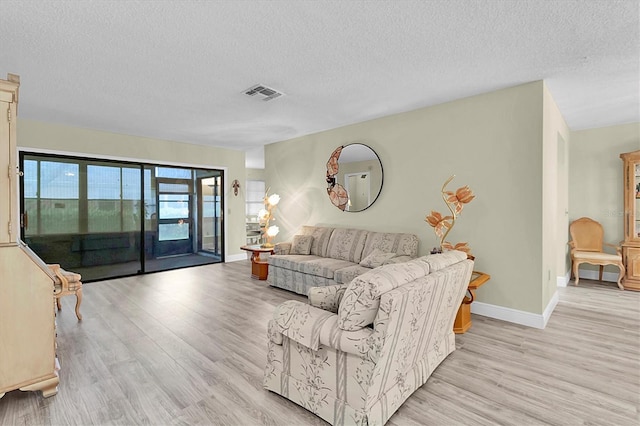 4841 Wakefield Ct Unit 4841, New Port Richey, FL 34655 - living room with light wood-style floors, a textured ceiling, and baseboards