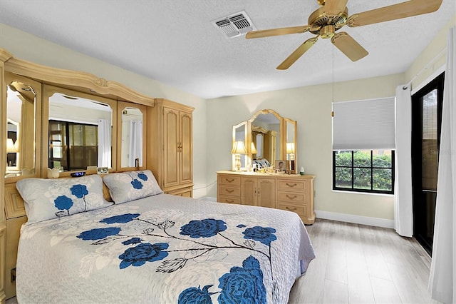 4841 Wakefield Ct Unit 4841, New Port Richey, FL 34655 - bedroom featuring light wood-style flooring, baseboards, a textured ceiling, and a ceiling fan