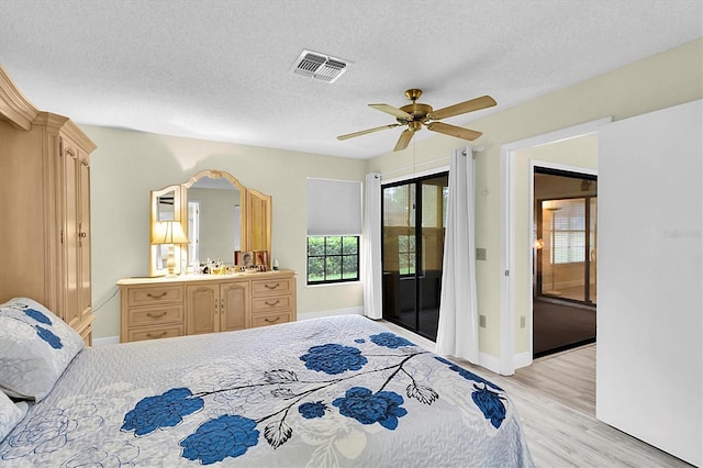 4841 Wakefield Ct Unit 4841, New Port Richey, FL 34655 - bedroom with access to exterior, light wood-style floors, baseboards, a textured ceiling, and ceiling fan