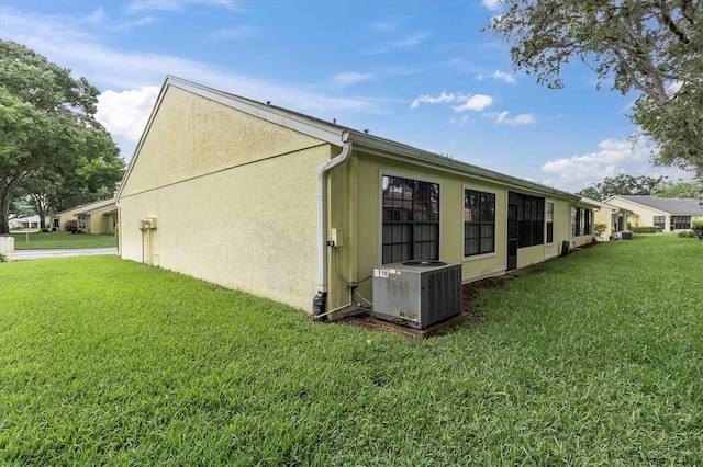 4841 Wakefield Ct Unit 4841, New Port Richey, FL 34655 - view of property exterior featuring central AC, a lawn, and stucco siding