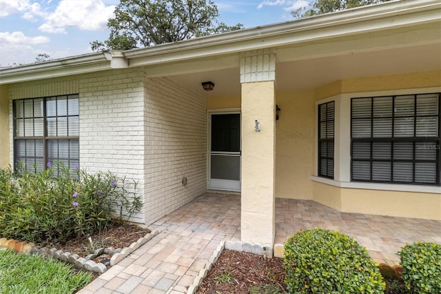 4841 Wakefield Ct Unit 4841, New Port Richey, FL 34655 - view of exterior entry with brick siding, a patio area, and stucco siding