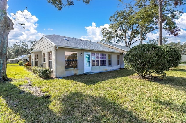 9529 Bunker Hill Ct Unit 9529, New Port Richey, FL 34655 - view of property exterior with stucco siding, a lawn, and roof with shingles