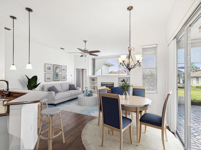 13922 Talmage Loop, Hudson, FL 34667 - dining room featuring plenty of natural light, a lit fireplace, ceiling fan, and wood finished floors