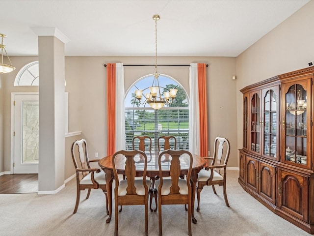 13922 Talmage Loop, Hudson, FL 34667 - dining space featuring a chandelier, healthy amount of natural light, light carpet, and baseboards