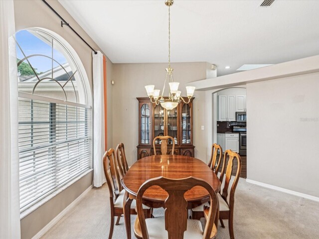 13922 Talmage Loop, Hudson, FL 34667 - dining space with a chandelier, light colored carpet, and baseboards