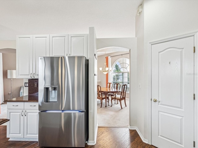 13922 Talmage Loop, Hudson, FL 34667 - kitchen with stainless steel refrigerator with ice dispenser, arched walkways, dark countertops, and white cabinets