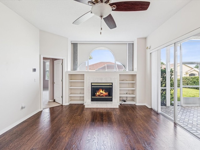 13922 Talmage Loop, Hudson, FL 34667 - unfurnished living room with ceiling fan, wood finished floors, a fireplace, baseboards, and built in shelves