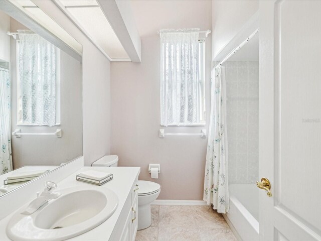 13922 Talmage Loop, Hudson, FL 34667 - full bath with toilet, vanity, baseboards, and shower / bath combo with shower curtain