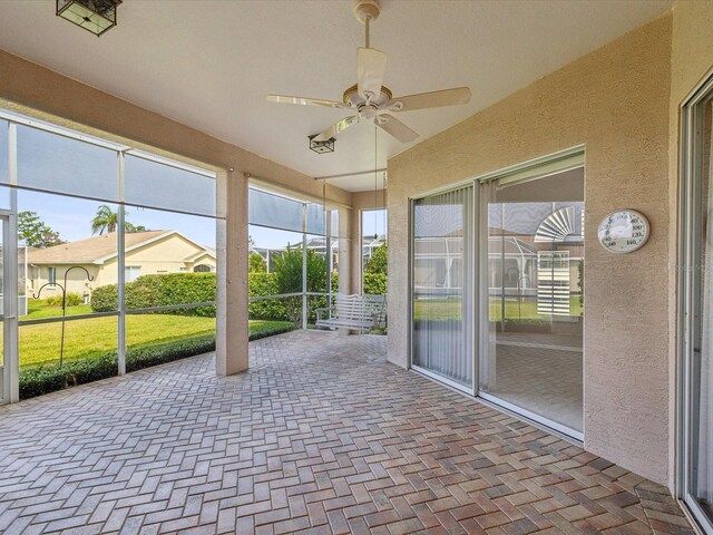 13922 Talmage Loop, Hudson, FL 34667 - unfurnished sunroom with ceiling fan, a textured wall, and brick patterned flooring