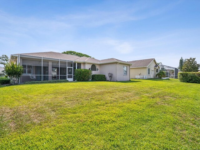 13922 Talmage Loop, Hudson, FL 34667 - rear view of property featuring a lawn, a sunroom, and stucco siding
