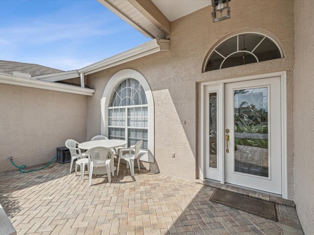 13922 Talmage Loop, Hudson, FL 34667 - property entrance featuring stucco siding, a patio, and outdoor dining space