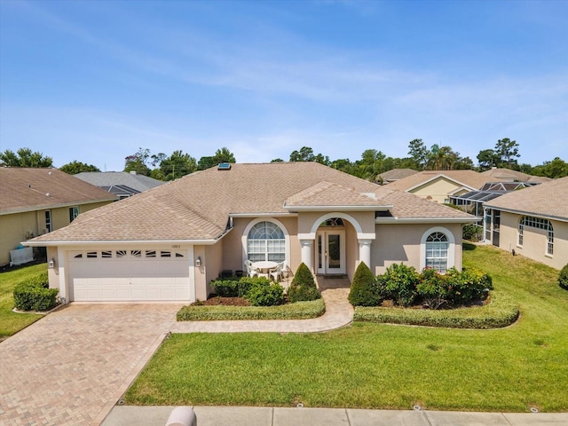 13922 Talmage Loop, Hudson, FL 34667 - view of front of house featuring stucco siding, a garage, decorative driveway, a front yard, and a shingled roof