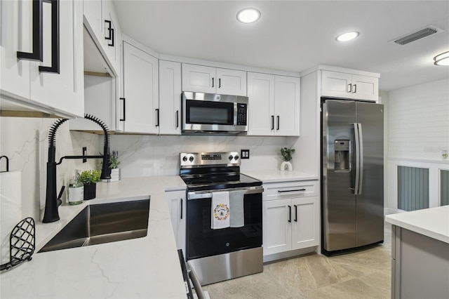 7545 Banner St, New Port Richey, FL 34653 - kitchen featuring stainless steel appliances, a sink, white cabinetry, backsplash, and recessed lighting