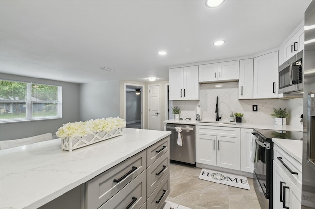 7545 Banner St, New Port Richey, FL 34653 - kitchen featuring stainless steel appliances, a sink, light stone countertops, tasteful backsplash, and recessed lighting