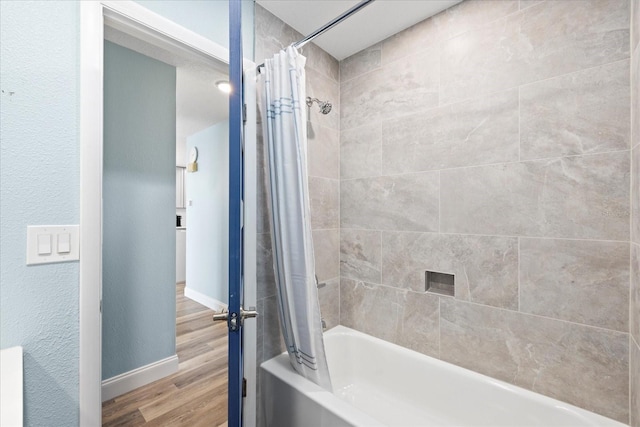 4939 Floramar Ter Unit 611, New Port Richey, FL 34652 - bathroom featuring shower / tub combo with curtain, wood finished floors, and baseboards