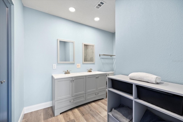 4939 Floramar Ter Unit 611, New Port Richey, FL 34652 - full bathroom with double vanity, wood finished floors, recessed lighting, and baseboards