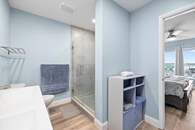 4939 Floramar Ter Unit 611, New Port Richey, FL 34652 - bathroom with wood finished floors, a stall shower, ceiling fan, toilet, and baseboards