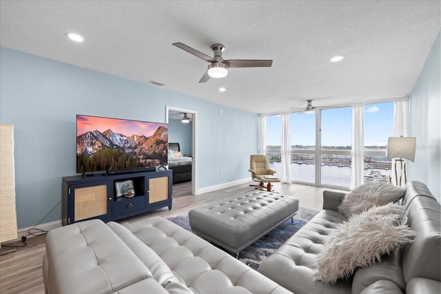 4939 Floramar Ter Unit 611, New Port Richey, FL 34652 - living room featuring a ceiling fan, a textured ceiling, wood finished floors, baseboards, and recessed lighting