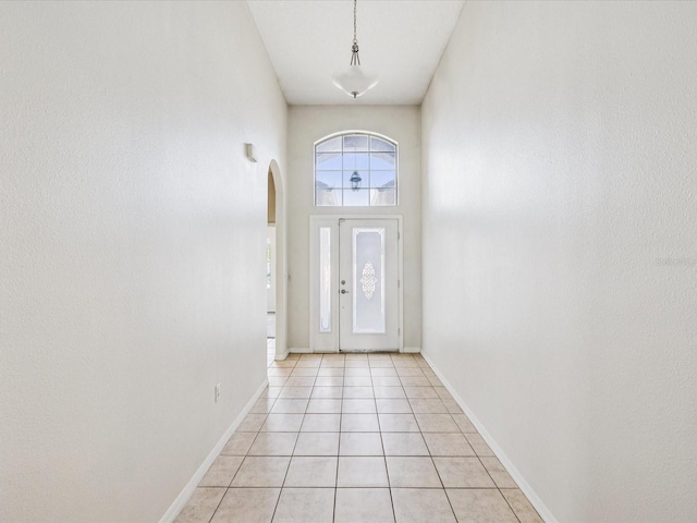 4266 High Ridge Ave, Spring Hill, FL 34609 - doorway featuring arched walkways, light tile patterned flooring, baseboards, and a towering ceiling