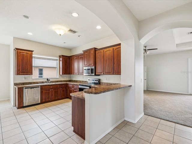 4266 High Ridge Ave, Spring Hill, FL 34609 - kitchen with appliances with stainless steel finishes, a sink, a peninsula, light tile patterned floors, and ceiling fan