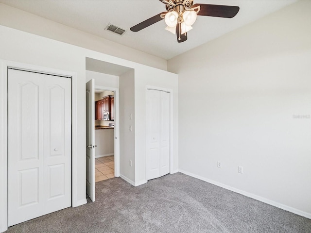 4266 High Ridge Ave, Spring Hill, FL 34609 - unfurnished bedroom featuring carpet flooring, multiple closets, baseboards, and a ceiling fan
