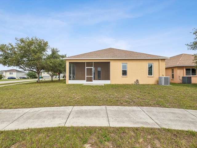 4266 High Ridge Ave, Spring Hill, FL 34609 - back of house featuring central air condition unit, a sunroom, a yard, and stucco siding