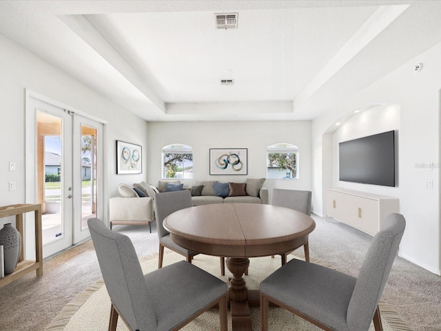 4266 High Ridge Ave, Spring Hill, FL 34609 - dining space with light colored carpet, a tray ceiling, and french doors