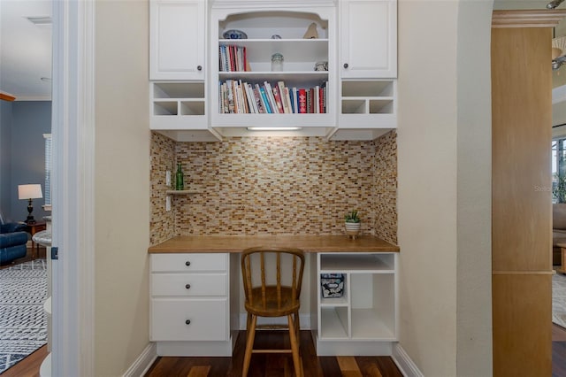 10531 Pontofino Cir, Trinity, FL 34655 - office area featuring built in desk, dark wood-type flooring, baseboards, and ornamental molding