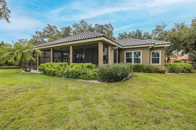10531 Pontofino Cir, Trinity, FL 34655 - rear view of house featuring a sunroom, a lawn, stucco siding, and a tile roof