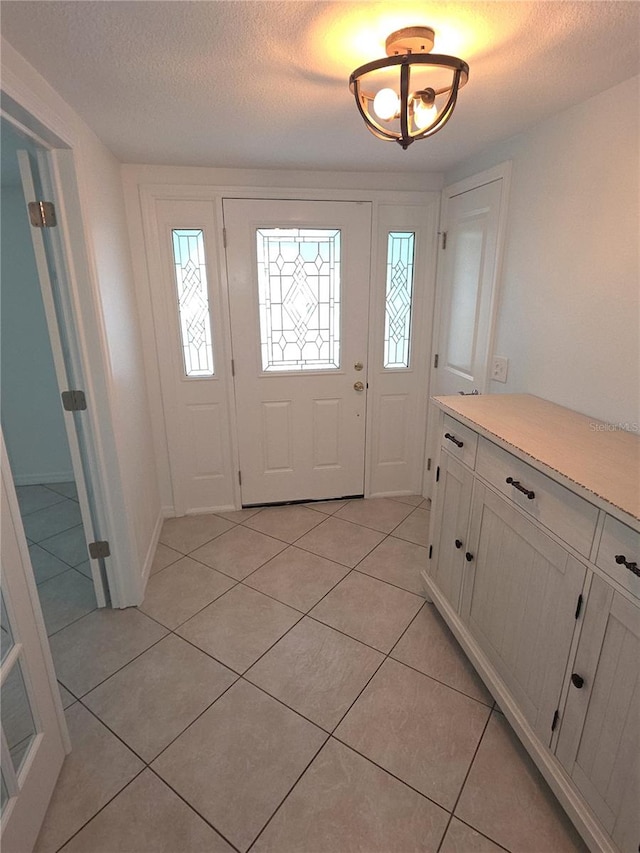 7313 Hatteras Dr, Hudson, FL 34667 - foyer entrance featuring light tile patterned floors and a textured ceiling