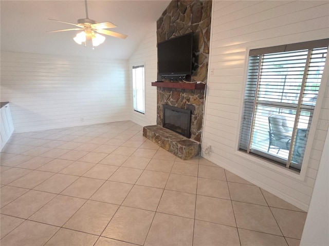 7313 Hatteras Dr, Hudson, FL 34667 - unfurnished living room featuring vaulted ceiling, a fireplace, light tile patterned floors, a ceiling fan, and wooden walls