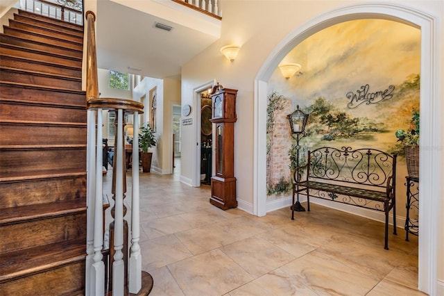 2880 Chelsea Pl N, Clearwater, FL 33759 - foyer featuring arched walkways, stairs, and light marble finish floors