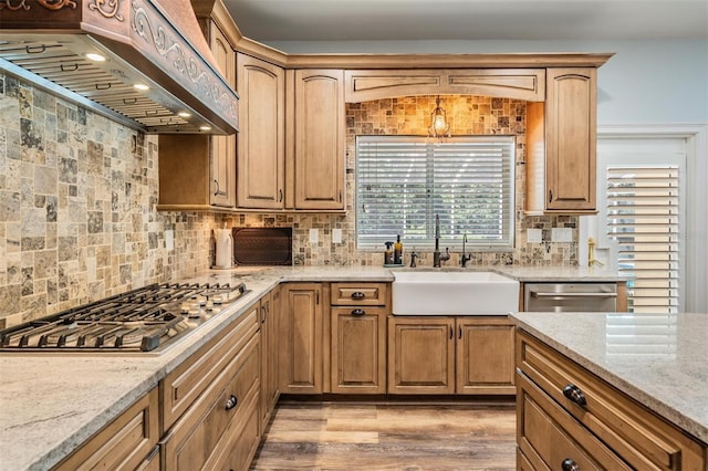 2880 Chelsea Pl N, Clearwater, FL 33759 - kitchen featuring appliances with stainless steel finishes, premium range hood, light stone counters, tasteful backsplash, and light wood-style floors