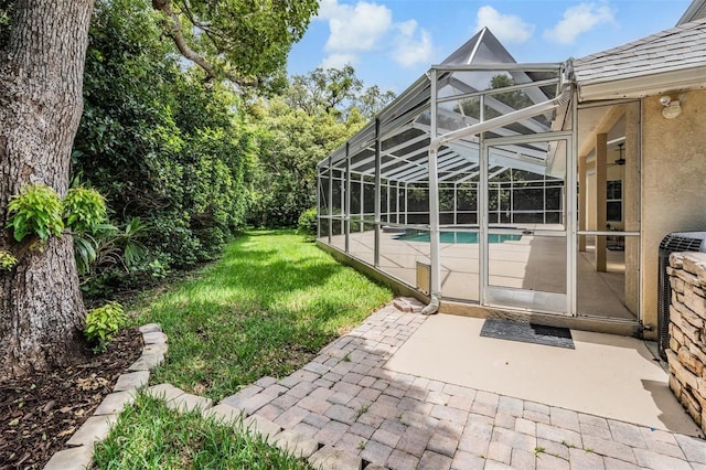 2880 Chelsea Pl N, Clearwater, FL 33759 - outdoor pool featuring a patio, a lawn, and glass enclosure