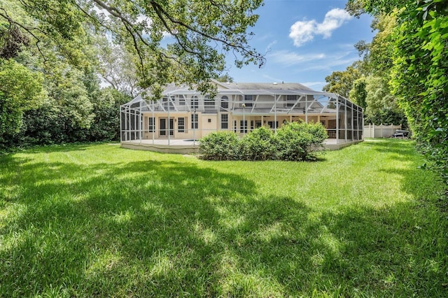 2880 Chelsea Pl N, Clearwater, FL 33759 - back of property featuring glass enclosure, a lawn, and a patio area